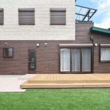 掃き出し窓から直結のウッドデッキと人工芝