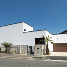 真っ白な塗り壁と沖縄のフェニックスのヤシが印象的なリゾートスタイルハウス