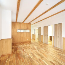 アカシアの床材に、杉の腰壁、梁見せ天井で統一感のある内装